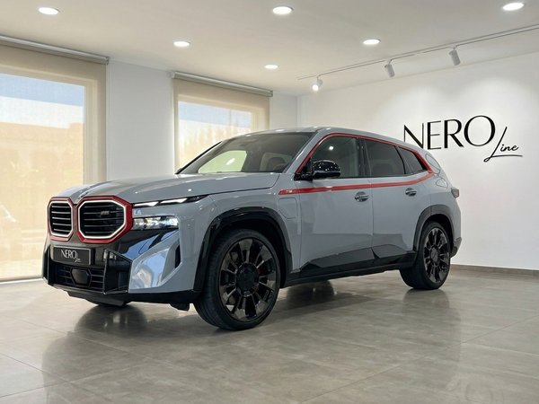 BMW XM Label Red — SUV de lujo en Madrid El BMW XM Label Red 2023 gris claro con detalles rojos se exhibe desde una vista tres cuartos frontal en un showroom de Madrid.