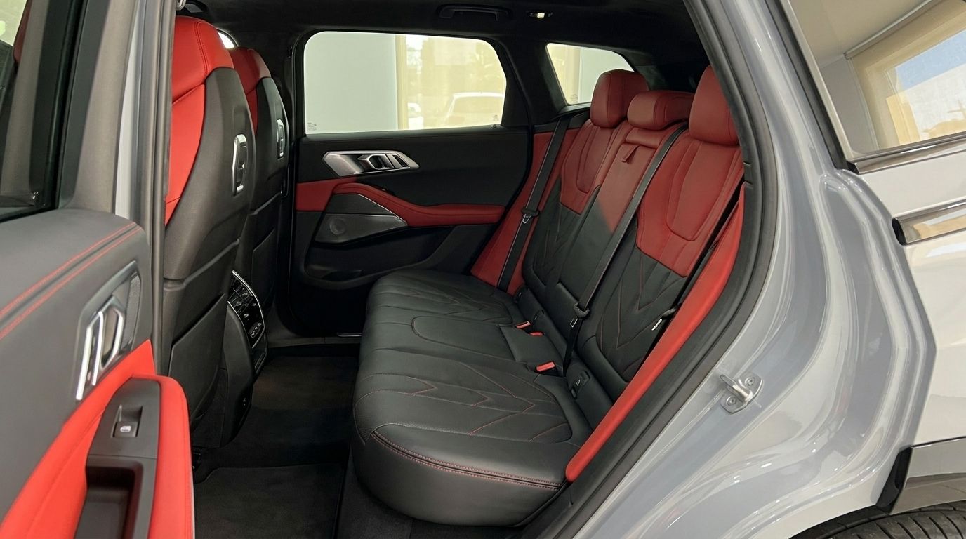 El interior trasero del BMW XM Label Red 2023 en Madrid, con asientos de cuero negro y llamativos detalles rojos.