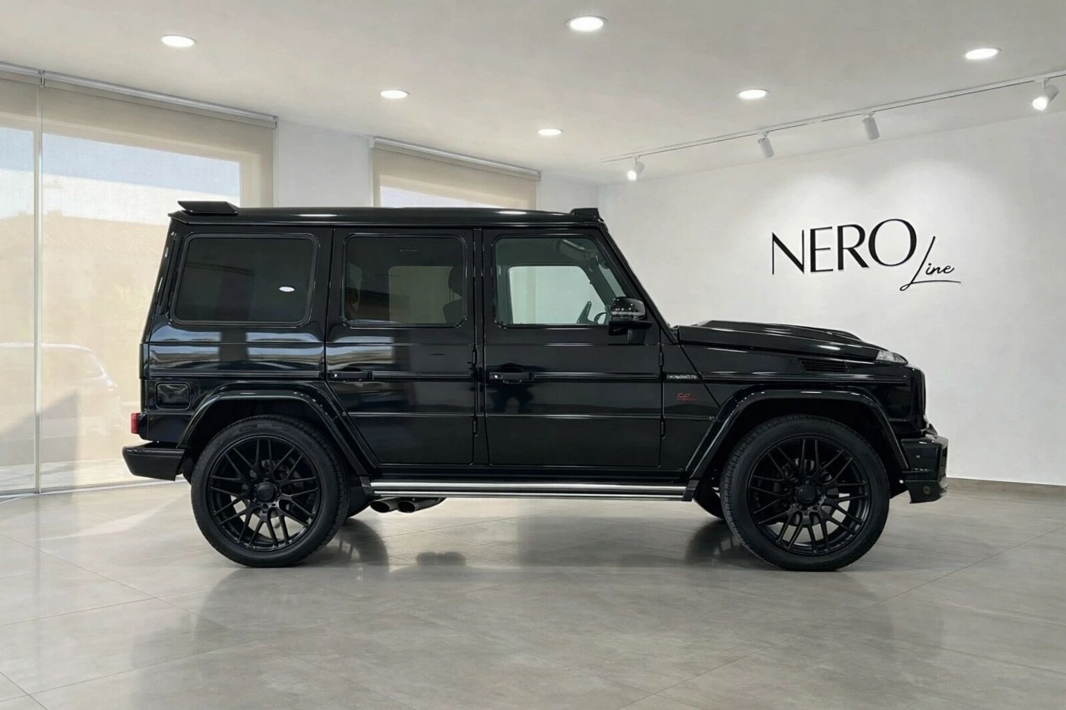 The black Brabus G800 Rocket, a Mercedes-Benz G-Class, is shown in a sleek side profile view, parked indoors in Alicante.
