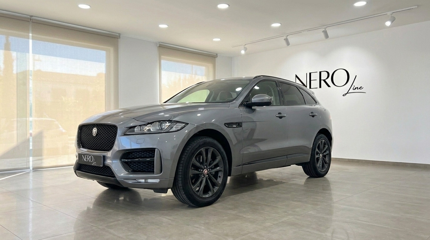 Jaguar F-Pace — Front three-quarter view, Alicante The metallic grey 2022 Jaguar F-Pace is showcased from a front three-quarter view in a bright showroom in Alicante.
