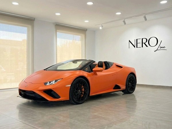 Lamborghini Huracan Evo Spyder — Barcelona Showroom The orange Lamborghini Huracan Evo Spyder convertible is showcased from the front-side in a bright showroom in Barcelona.