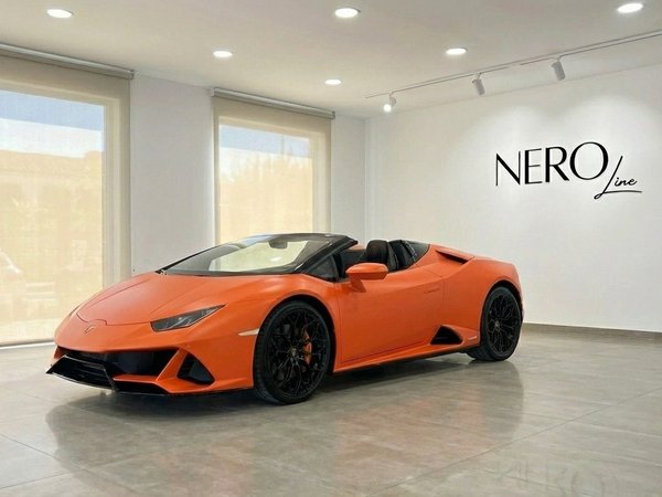 Lamborghini Huracan Evo Spyder — Showroom Madrid Un Lamborghini Huracan Evo Spyder descapotable naranja está aparcado en una sala de exposición moderna en Madrid, con el logo NEROline.