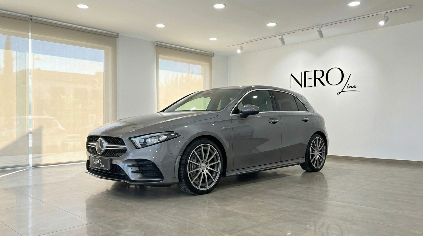 Mercedes-Benz A 45 AMG — Luxury Car Rental Alicante The metallic grey 2022 Mercedes-Benz A 45 AMG is showcased from a front three-quarter view in a showroom in Alicante.