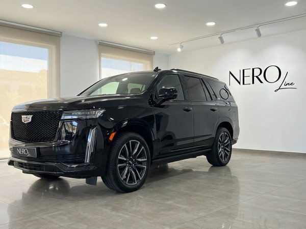 Cadillac Escalade — Front three-quarter view, Barcelona The black 2024 Cadillac Escalade is showcased from a front three-quarter view inside a bright showroom in Barcelona.