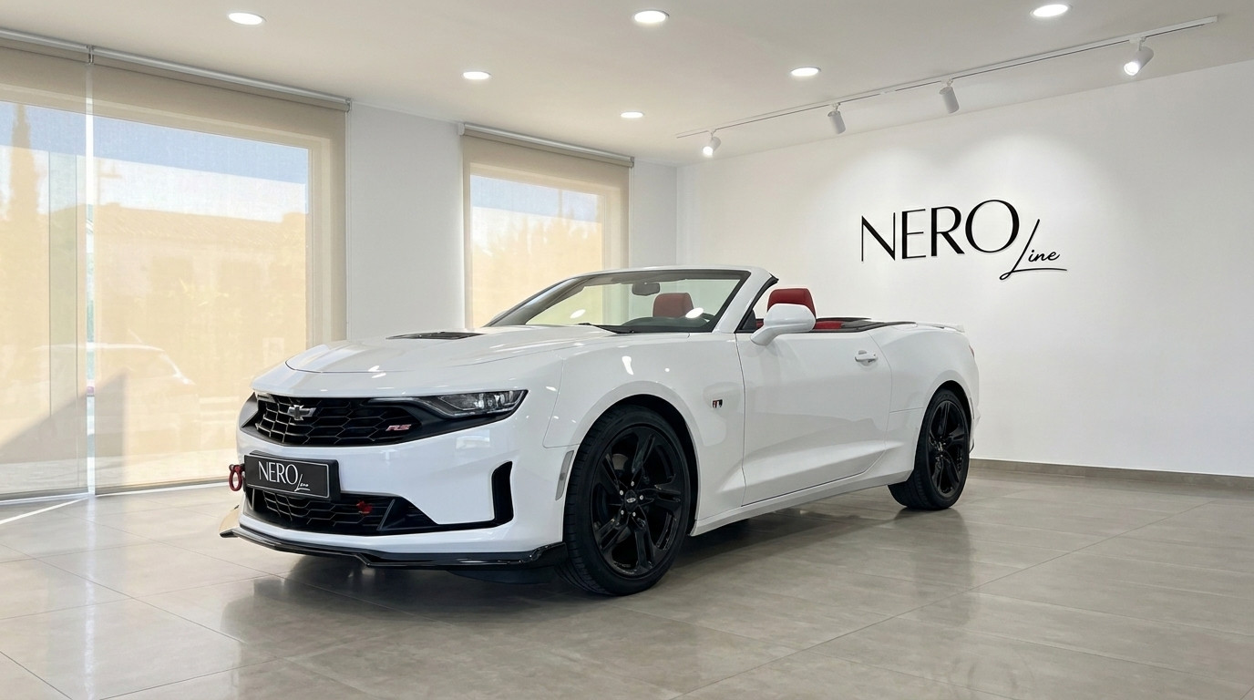 Chevrolet Camaro Cabrio 3.6 — White convertible in Alicante A white 2022 Chevrolet Camaro Cabrio 3.6 convertible, with its top down and red interior, parked in a showroom in Alicante.