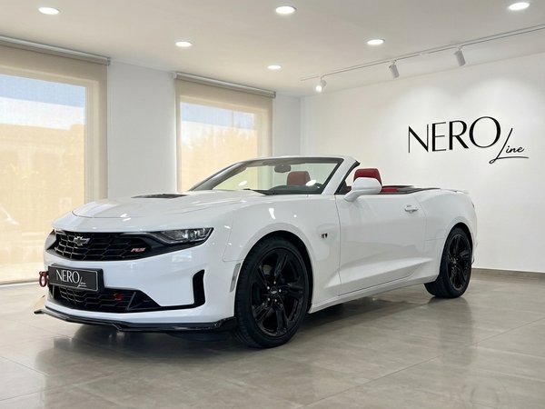 Chevrolet Camaro Cabrio 3.6 — White convertible in Alicante A white 2022 Chevrolet Camaro Cabrio 3.6 convertible, with its top down and red interior, parked in a showroom in Alicante.