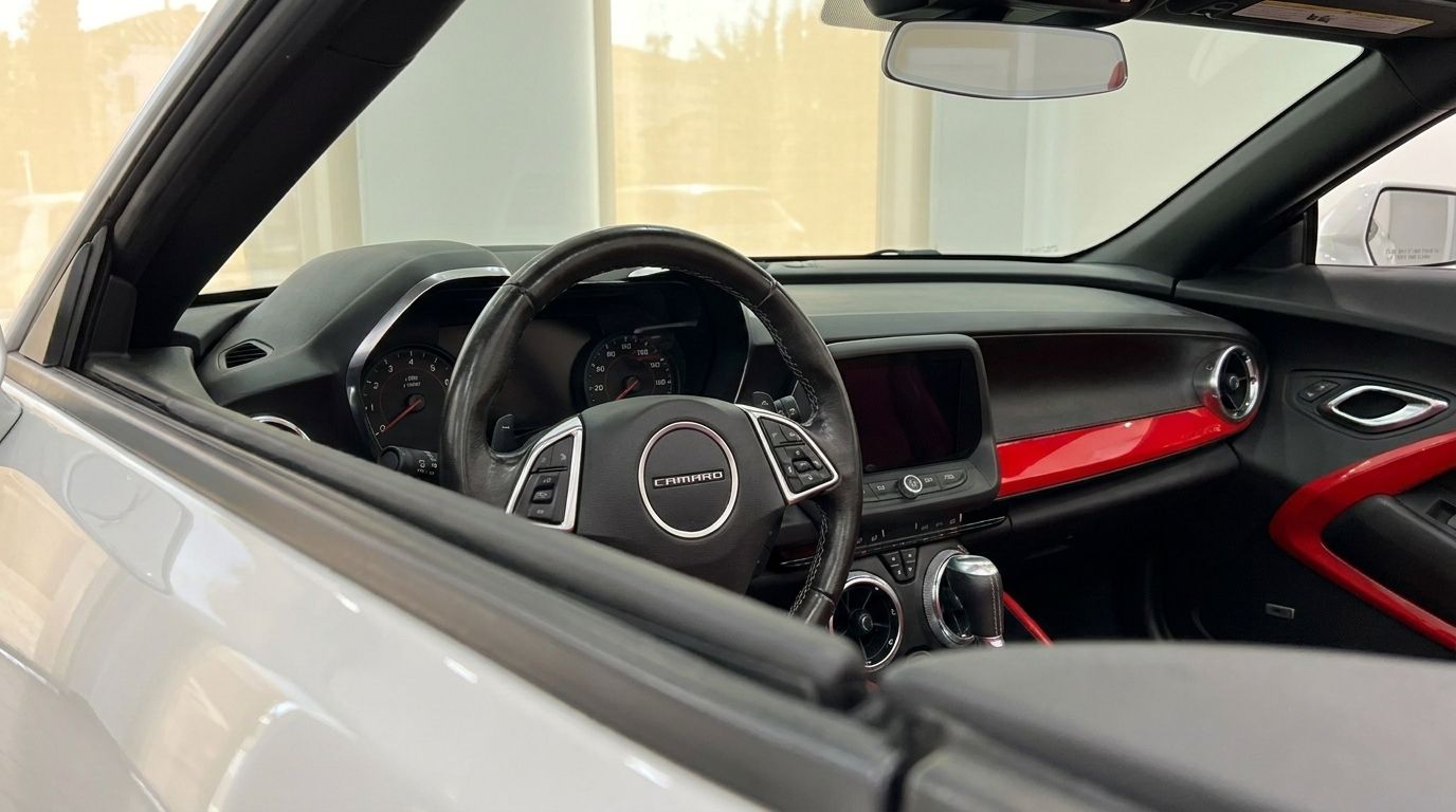 The image shows the interior dashboard and steering wheel of the Chevrolet Camaro Cabrio 3.6 in Alicante, featuring red accents.
