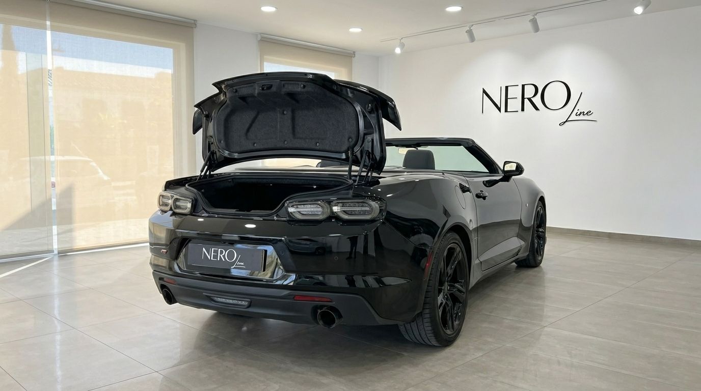 O elegante Chevrolet Camaro Cabriolet 2021 preto está estacionado num showroom em Alicante, exibindo a bagageira aberta e o design traseiro.