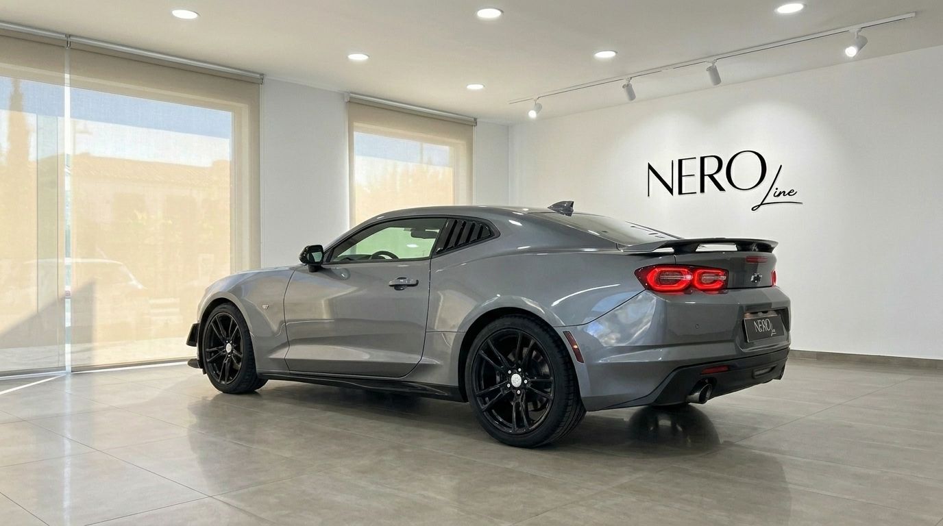 O Chevrolet Camaro cinza é capturado de um ângulo traseiro de três quartos, exibindo seu design elegante em um showroom em Alicante.