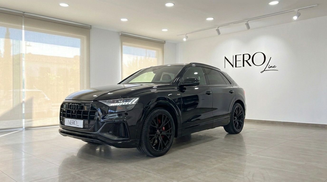 The black Audi Q8 S-line is showcased from a front three-quarter angle in a bright showroom in Marbella.
