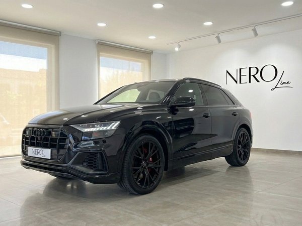Audi Q8 S-line — Front view in Marbella showroom The black Audi Q8 S-line is showcased from a front three-quarter angle in a bright showroom in Marbella.