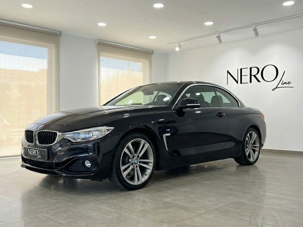 BMW 420 Cabriolet — Showroom view in Alicante The black BMW 420 Cabriolet, with its hardtop up, is showcased from a front-three-quarter angle in a modern Alicante showroom.