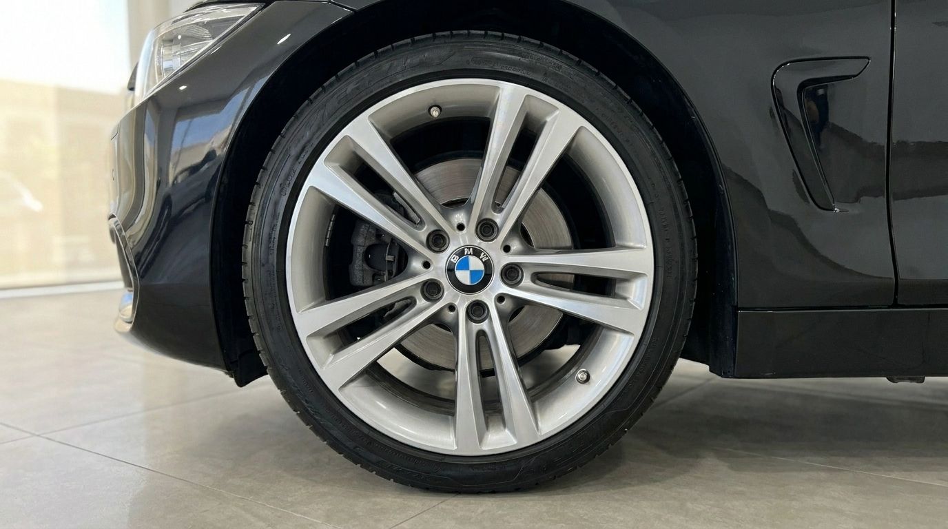 Close-up of the front wheel and side panel of the black BMW 420 Cabriolet in Alicante, highlighting the alloy rim and brake.