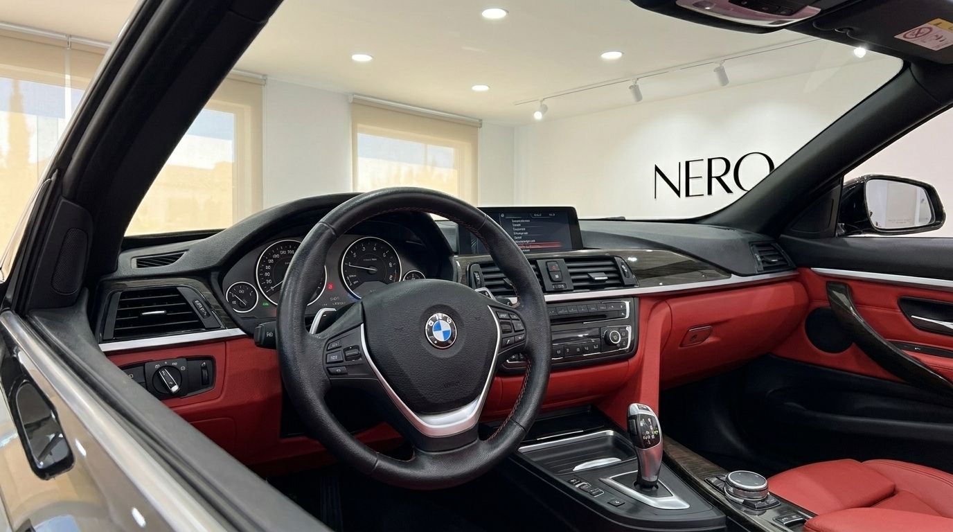 The luxurious interior of the BMW 420 Cabriolet in Alicante, showcasing the steering wheel, dashboard, and vibrant red leather.