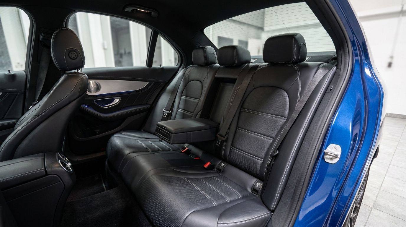 The Mercedes-Benz C63S AMG's luxurious black leather rear seats with an armrest are visible from the passenger side in Zurich.