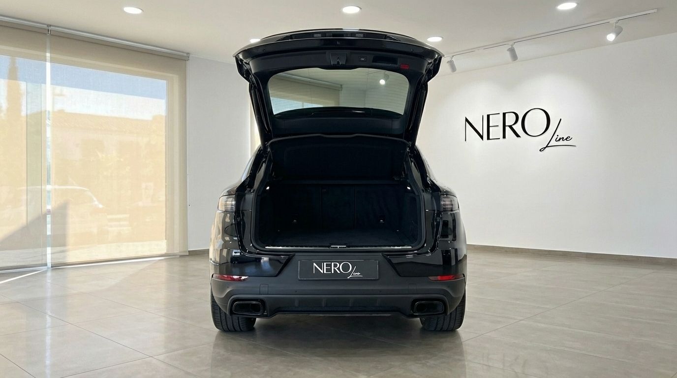 The black 2025 Porsche Cayenne Coupe is shown from the rear with its trunk open, ready for luggage in Marbella.