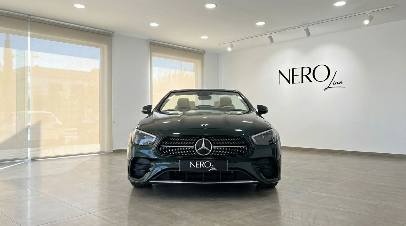 Dark green Mercedes-Benz E300 Cabrio with its top down, showcasing its front in a bright showroom in Alicante.