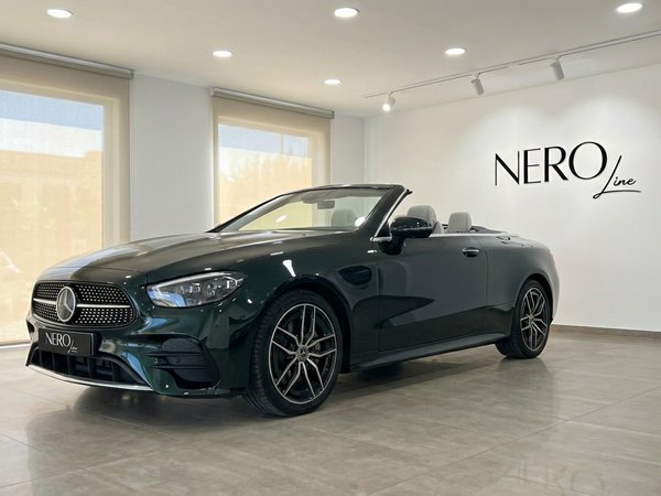 Mercedes-Benz E300 Cabrio — Showroom Alicante Dark green Mercedes-Benz E300 Cabrio, convertible top down, showcased in a modern showroom in Alicante.