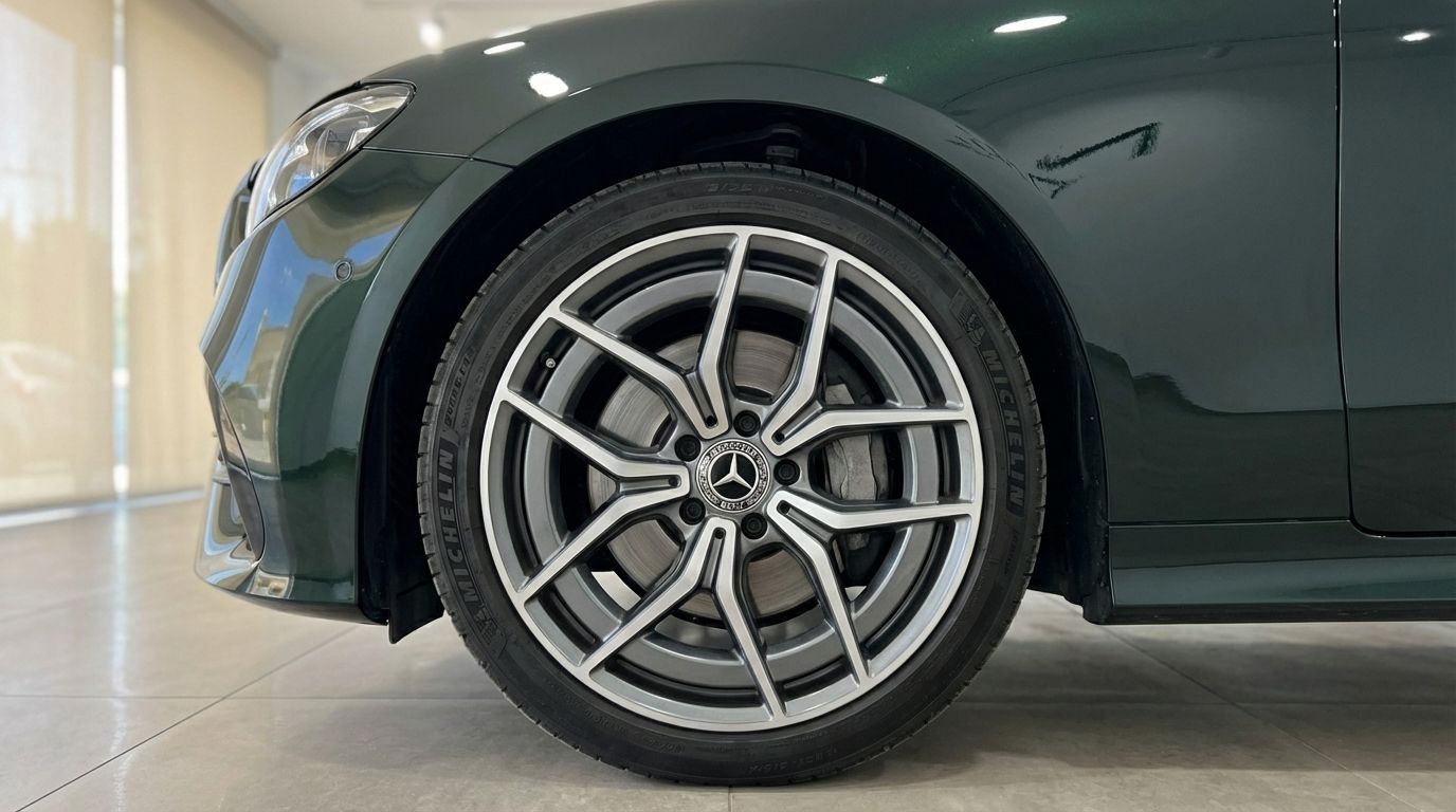 Front wheel and dark green fender of the Mercedes-Benz E300 Cabrio in Alicante, showcasing the distinctive alloy rim.