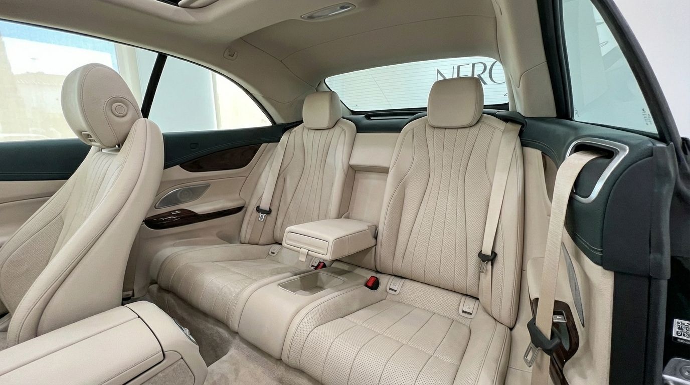 View of the luxurious beige leather rear seats and front passenger seat inside the Mercedes-Benz E300 Cabrio in Alicante.
