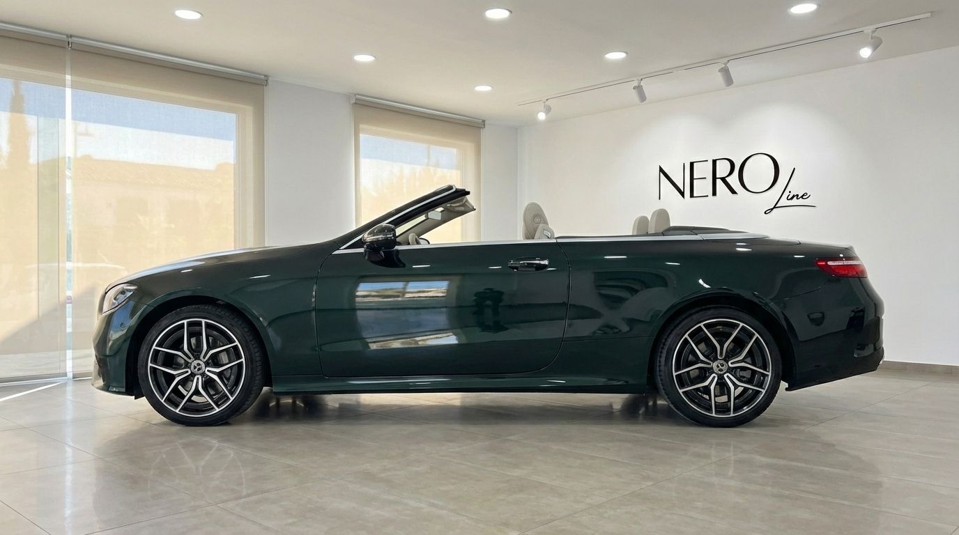 Dark green Mercedes-Benz E300 Cabrio with its top down, showcasing its side profile in a showroom in Alicante.