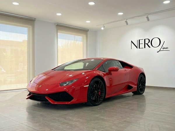Lamborghini Huracan LP610-4 — Showroom en Madrid El Lamborghini Huracan LP610-4 rojo de carreras se exhibe desde un ángulo frontal tres cuartos en una moderna sala de exposición en Madrid.