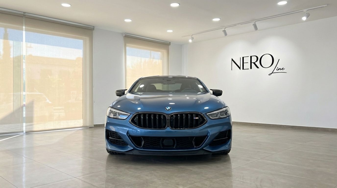 Front view of the sky blue 2022 BMW M850i Carbon Core Edition in a modern showroom in Alicante.
