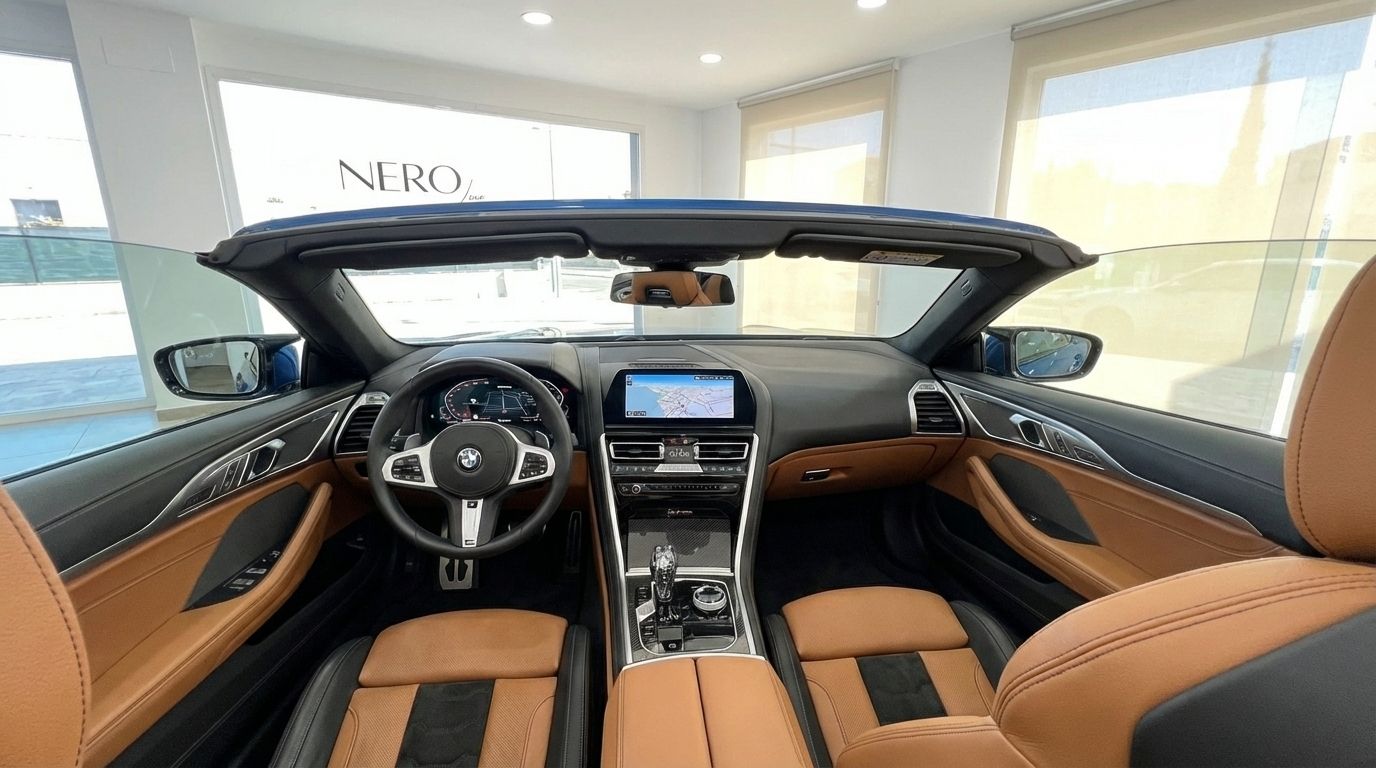 The luxurious interior of the BMW M850i Carbon Core Edition convertible in Alicante, featuring brown and black leather seats, a detailed dashboard, and a central display.