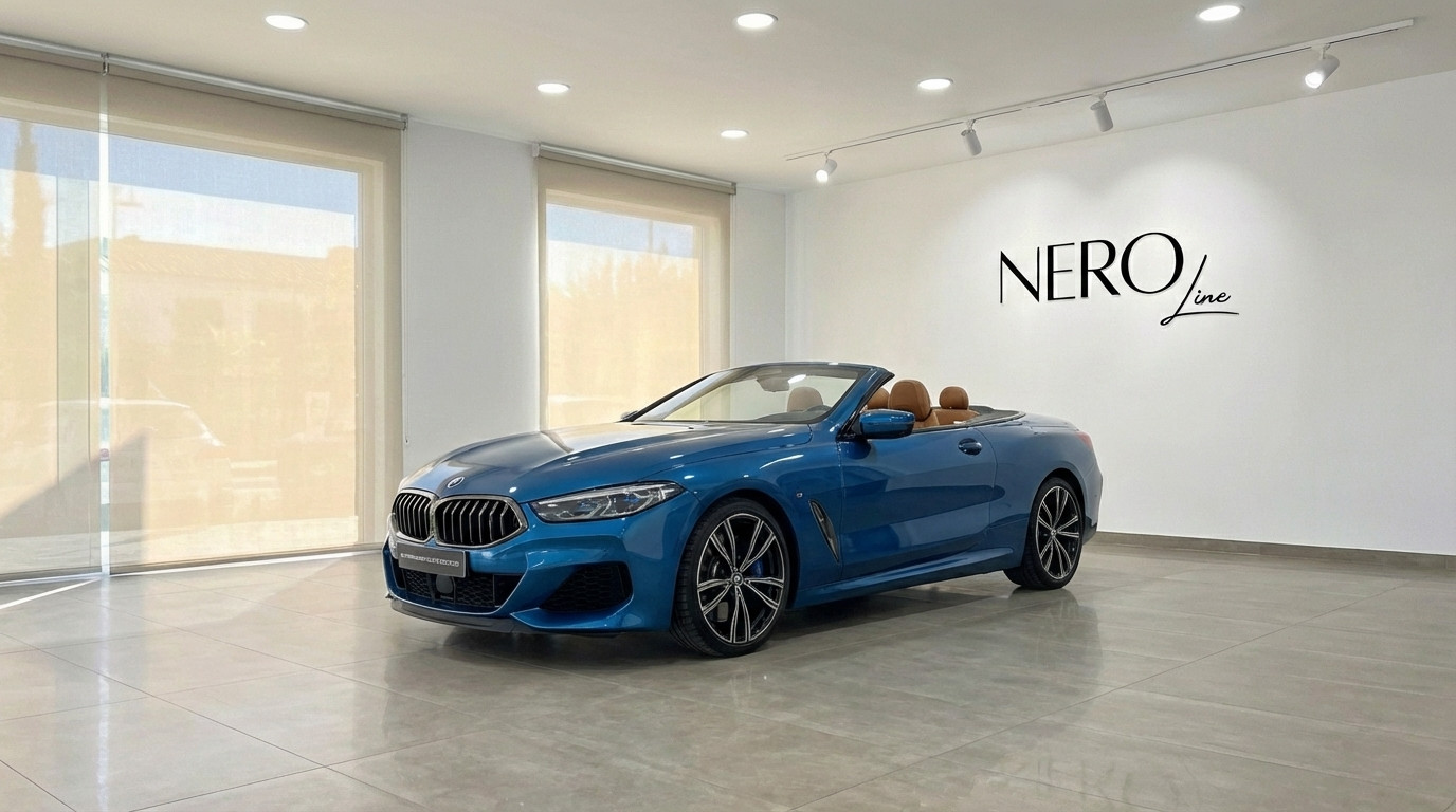 BMW M850i Carbon Core Edition — Showroom Alicante The sky blue BMW M850i Carbon Core Edition convertible with its top down and tan interior is displayed in a showroom in Alicante.