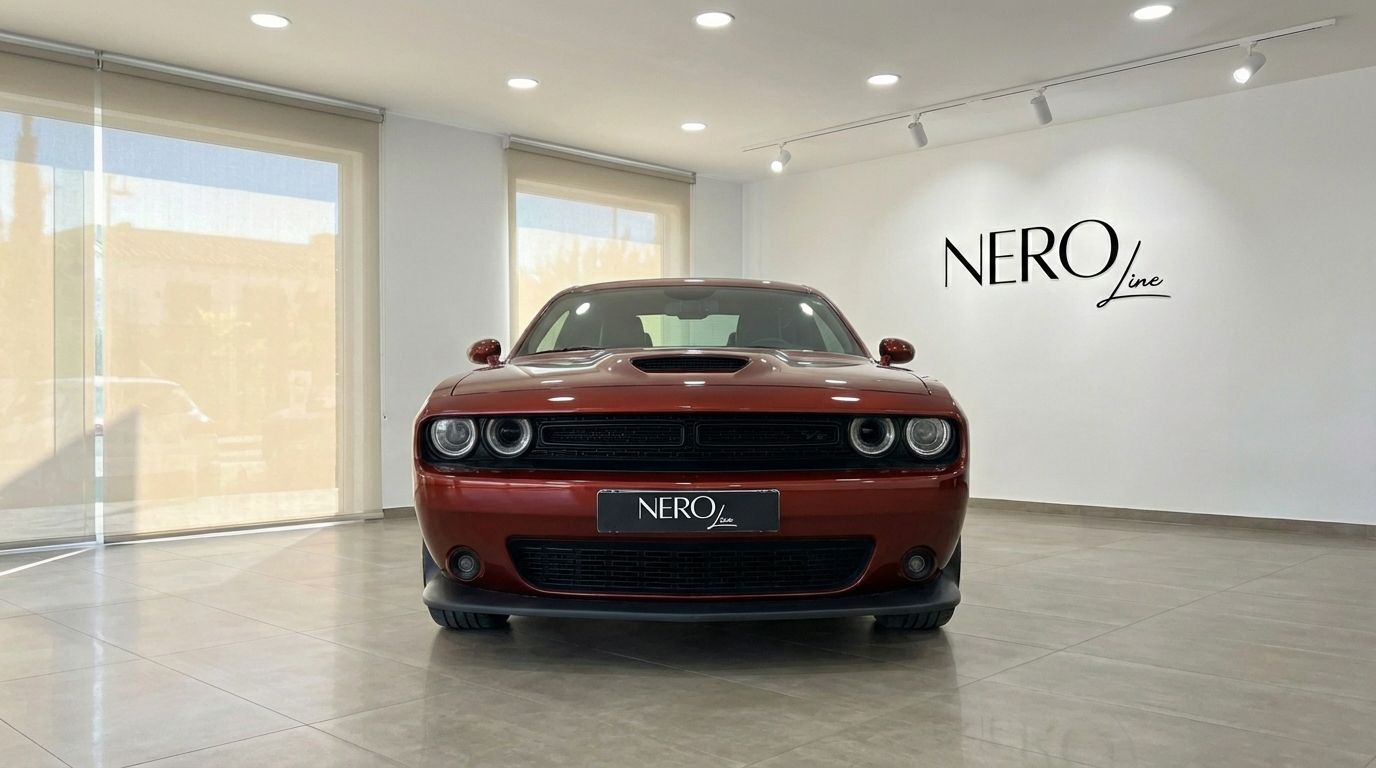 A burnt orange Dodge Challenger V6 is parked head-on in a showroom in Alicante, with the NEROline logo visible.