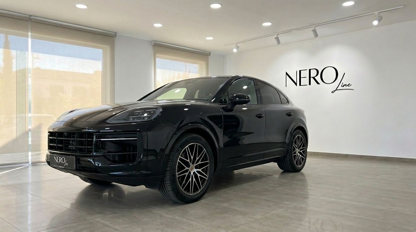 The gloss black 2026 Porsche Cayenne is showcased from a front three-quarter angle in a bright Alicante showroom.
