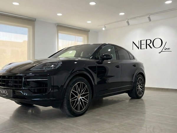Porsche Cayenne — Front three-quarter view in showroom The gloss black 2026 Porsche Cayenne is showcased from a front three-quarter angle in a bright Alicante showroom.