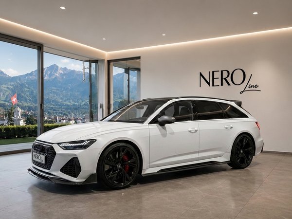 Audi RS6 — Luxury car in Zurich showroom. A white Audi RS6 is parked in a modern showroom with large windows overlooking the scenic mountains of Zurich.