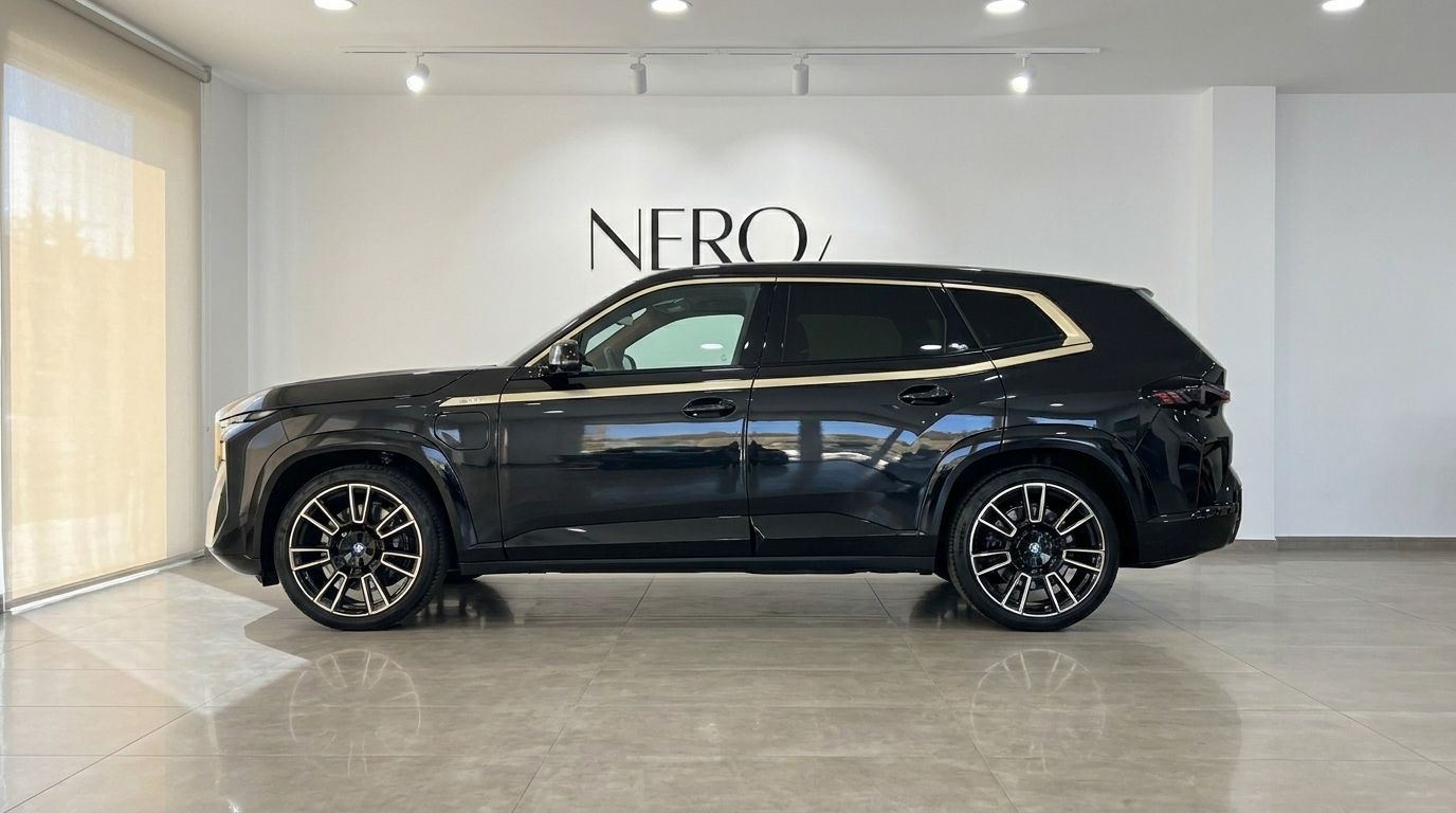 The 2025 BMW XM in Gloss Black, showcasing its sleek side profile inside a showroom in Alicante.