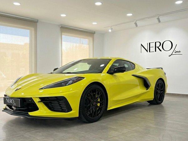 Chevrolet Corvette Stingray C8 — Showroom Alicante The neon yellow Chevrolet Corvette Stingray C8 is showcased from a front three-quarter view in a showroom in Alicante.