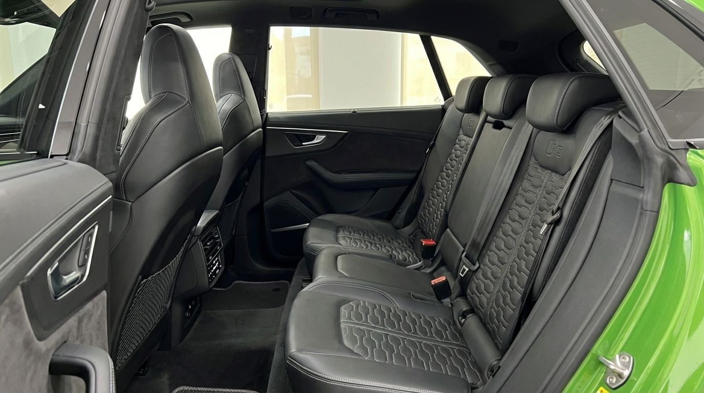 Los lujosos asientos traseros de cuero negro con costuras distintivas dentro del Audi RS Q8, disponible en Madrid.