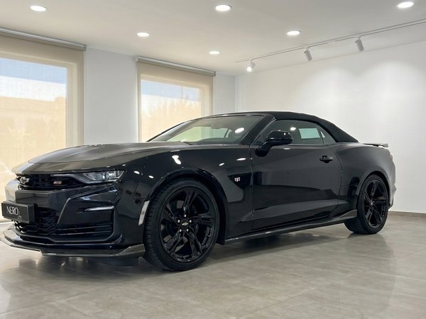 Chevrolet Camaro Cabriolet — Front-side view Alicante The gloss black 2021 Chevrolet Camaro Cabriolet is showcased from a front-side view indoors in Alicante.