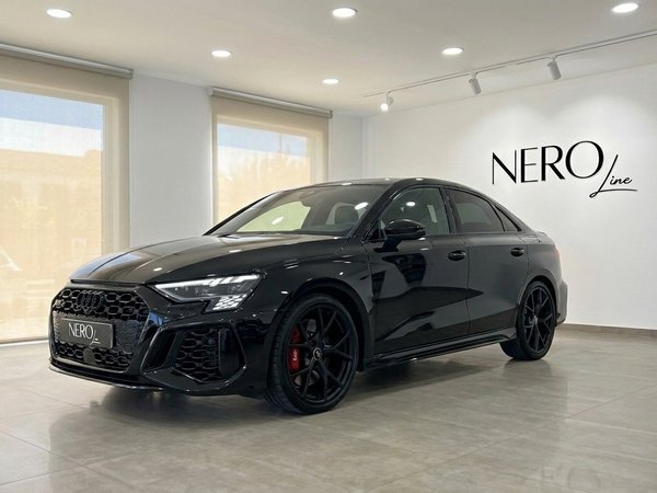 Audi RS3 Saloon — Front three-quarter view Marbella The sleek black 2022 Audi RS3 Saloon is showcased from a front three-quarter angle in a modern Marbella showroom.
