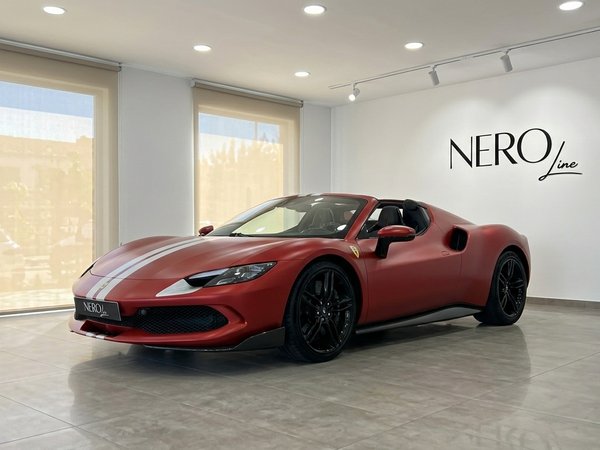 Ferrari 296 GTS Assetto Fiorano — Showroom Mallorca The matte red Ferrari 296 GTS Assetto Fiorano convertible is parked indoors, showcasing its sleek design in Mallorca.