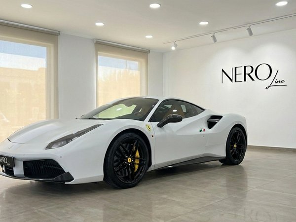 Ferrari 488 GTB — Luxury supercar in Madrid The white Ferrari 488 GTB supercar is parked in a showroom with the Nero Line logo on the wall in Madrid.