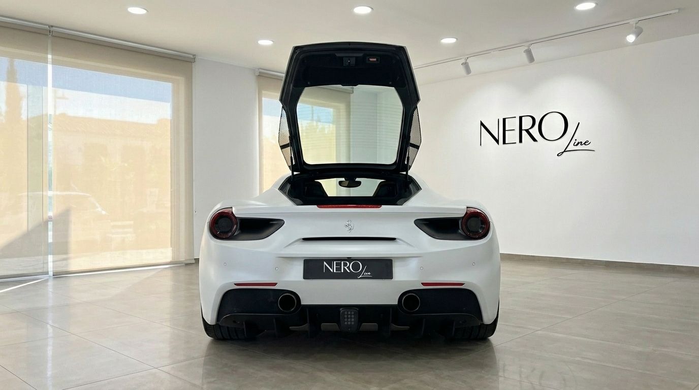 El Ferrari 488 GTB 2024 blanco mate se exhibe desde la parte trasera con la cubierta del motor abierta en un concesionario de Madrid.