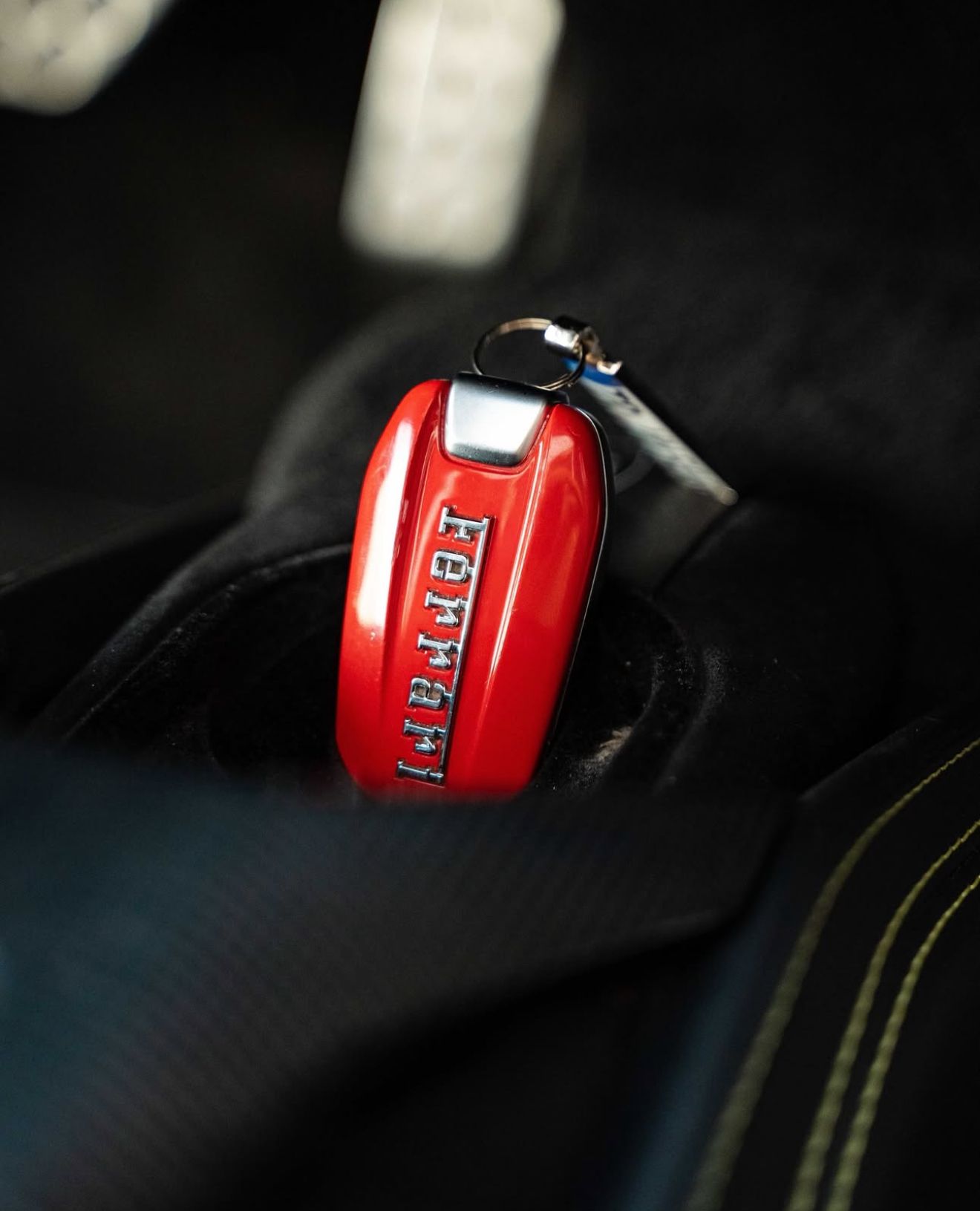 Primer plano del mando rojo del Ferrari 488 Spider con el logo de la marca, dentro del coche de lujo en Madrid.