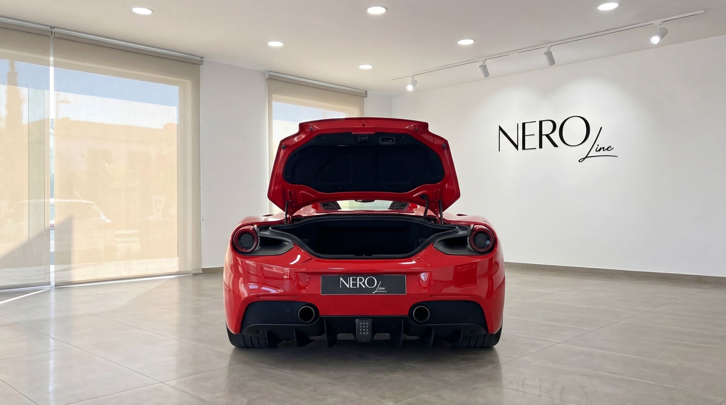 The racing red Ferrari 488 Spider is shown from the rear with its engine cover open in a showroom in Mallorca.