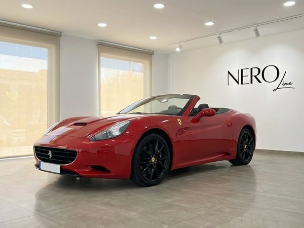 Ferrari California — Red convertible in Alicante The red Ferrari California convertible is displayed in a showroom with the top down, showcasing its elegant design in Alicante.