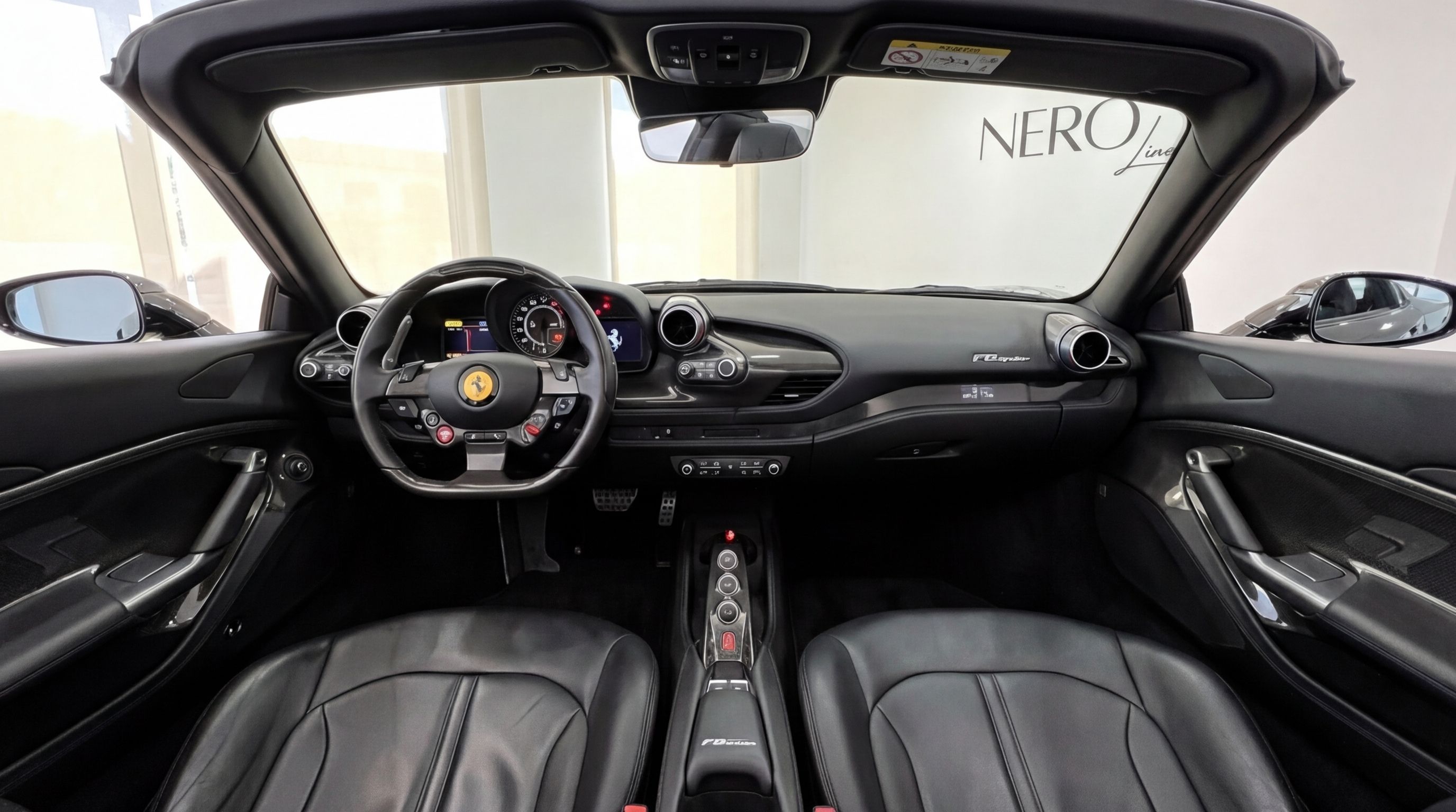 The luxurious black interior of the 2023 Ferrari F8 Spider in Ibiza, showcasing its detailed cockpit, dashboard, and leather seats.
