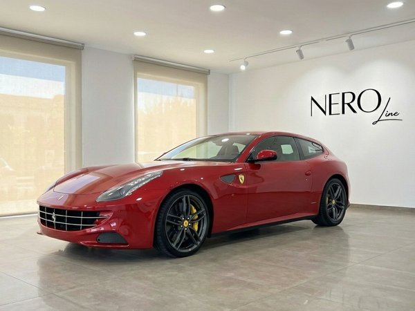 Ferrari FF — Front three-quarter view in showroom The racing red 2016 Ferrari FF is prominently displayed in a modern showroom in Valencia, showcasing its sleek front three-quarter view.