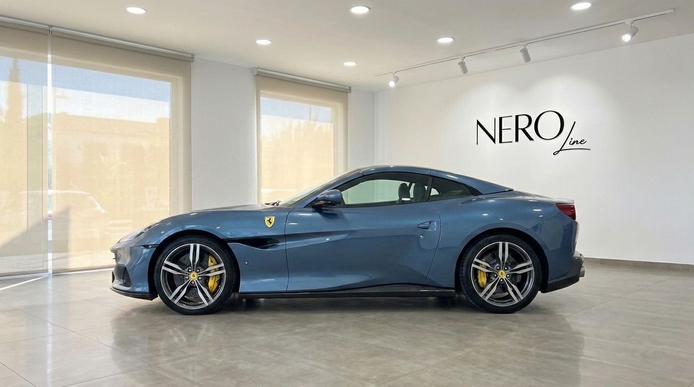 The metallic Blu Roma 2022 Ferrari Portofino M is showcased from a perfect side profile in a bright showroom in Mallorca.
