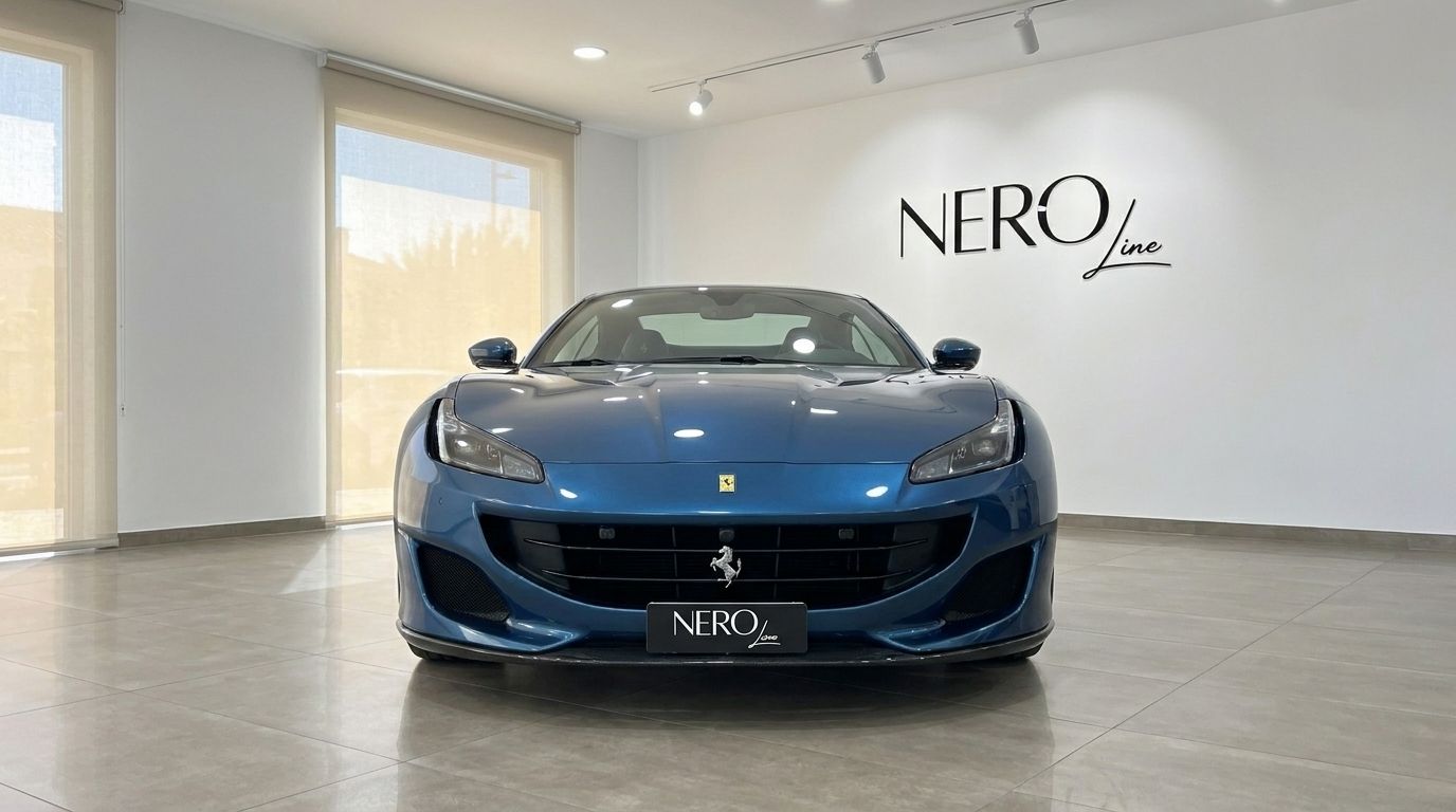 The metallic Blu Roma 2022 Ferrari Portofino M is showcased from a front view in a bright showroom in Mallorca.