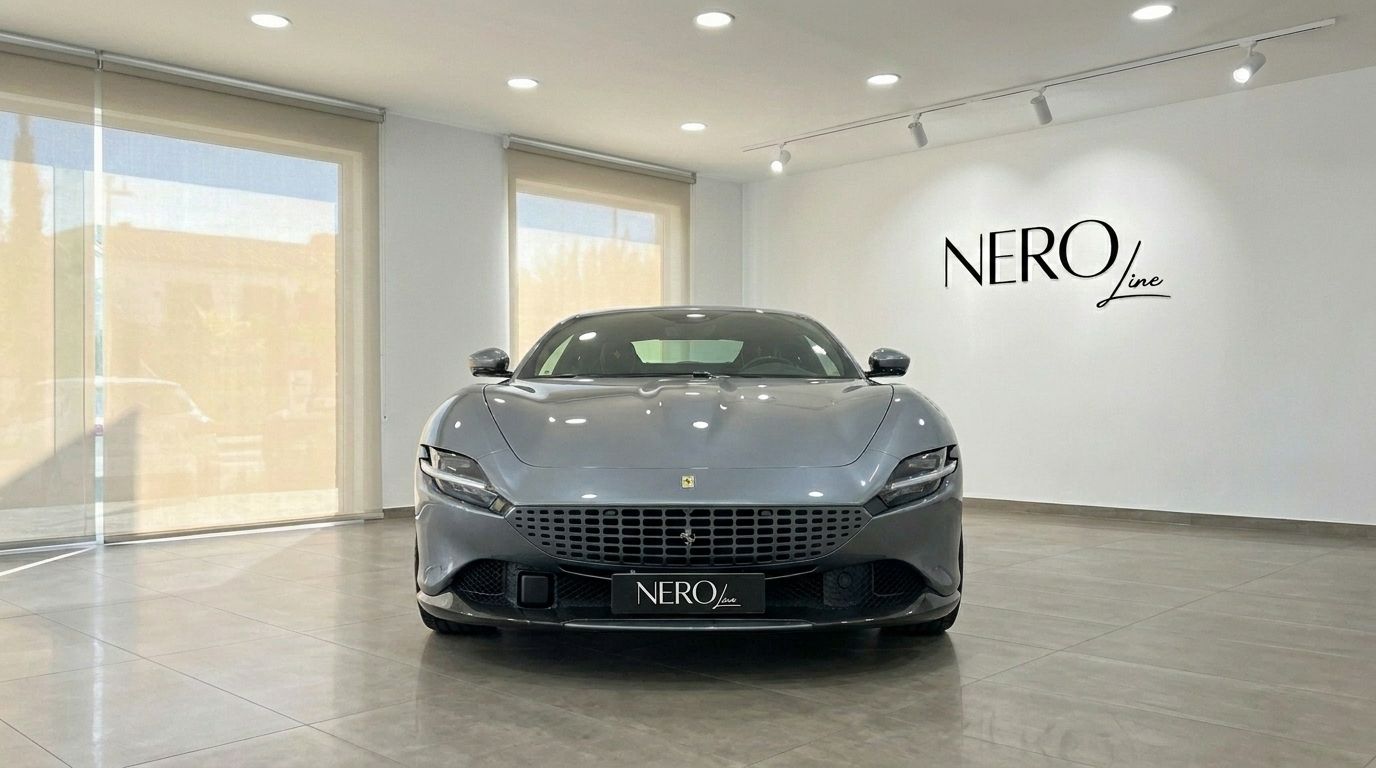 El elegante Ferrari Roma gris de 2022 se exhibe de frente en un moderno showroom en Madrid.