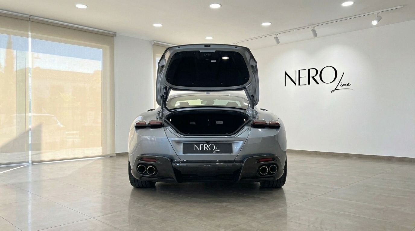 El Ferrari Roma gris se ve desde la parte trasera con el maletero abierto, mostrando su diseño en un concesionario de Madrid.